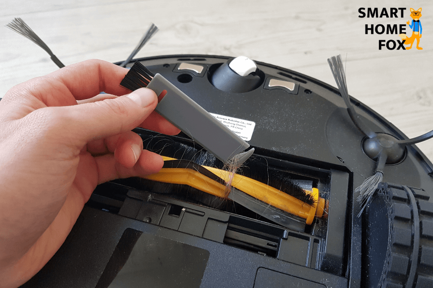 Removing hair from the main brush with the included cleaning tool 